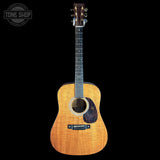 Acoustic guitar with a visible brand logo on a black background
