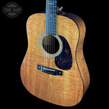 Acoustic guitar with a visible brand logo on a black background