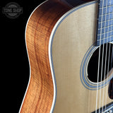 Close-up of an acoustic guitar with a visible brand logo in the corner.
