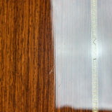 Close-up of a polished wooden surface with a glossy brown woodgrain finish and a light-colored decorative inlay line.