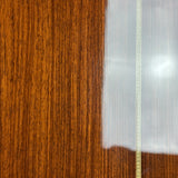 Close-up of a polished wooden surface with a warm brown woodgrain and a narrow decorative gold-toned inlay line running vertically.