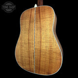 Acoustic guitar body with a visible brand logo in the corner