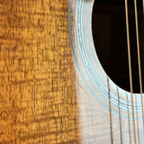 Close-up of a wooden acoustic guitar with a focus on the soundhole and strings.