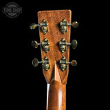 Close-up of a guitar headstock with tuning pegs on a black background, featuring the Tone Shop logo.
