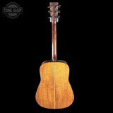 Back view of a wooden acoustic guitar on a black background with 'Tone Shop' logo.