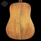 Back of a wooden acoustic guitar with 'Tone Shop' logo in the corner.