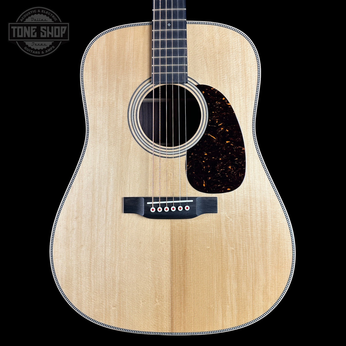 Acoustic guitar with a visible brand logo on a black background