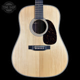 Acoustic guitar with a visible brand logo on a black background