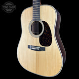 Acoustic guitar with a visible brand logo on a black background