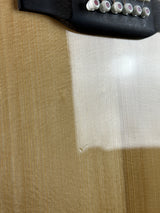 Close-up of a wooden surface with a white cloth and black object with buttons.