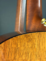 Close-up of a wooden guitar with a focus on the neck and headstock.