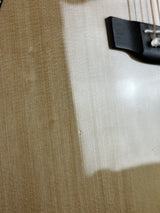 Close-up of a guitar on a white surface with a brown background