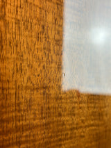 Close-up of a wooden surface with a metallic object partially visible