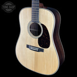 Acoustic guitar with a visible brand logo on a black background