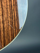 Close-up of a wooden surface with a metallic rim on a dark background