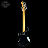 The back view of a black electric guitar with a natural maple neck, shown against a solid black background. A Tone Shop watermark is visible in the top-left corner.