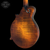 Close-up of a wooden mandolin on a black background with 'Tone Shop' logo.