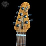 Close-up of a guitar headstock with 'Tone Shop' logo in the corner
