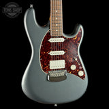 Electric guitar with a tortoiseshell pickguard on a black background, featuring the Tone Shop logo.