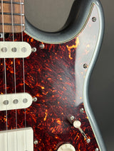 Close-up of a guitar with tortoiseshell finish and silver hardware.