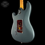 Electric guitar with a dark gray finish on a black background, featuring the Tone Shop logo.