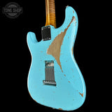 A custom electric guitar body in distressed light blue with a large natural wood patch on the back, shown against a solid black background. A Tone Shop watermark is visible in the top left corner.