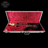 Guitar in a red-lined case with 'Tone Shop' logo.