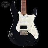 Black electric guitar with white pickguard on a black background, featuring 'Tone Shop' logo.