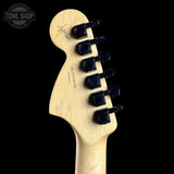Guitar headstock with tuning pegs on a black background, featuring the Tone Shop logo.