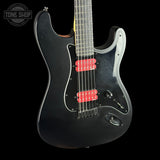 Black electric guitar with red pickups on a black background, featuring 'Tone Shop' logo.
