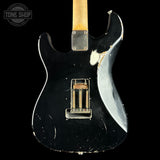 Black electric guitar with white pickguard on a black background, featuring 'Tone Shop' logo.