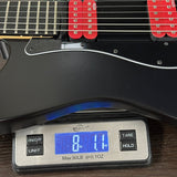 Guitar being weighed on a digital scale with a blue display showing weight.