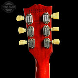 Close-up of a red guitar headstock with tuning pegs on a black background, featuring 'Tone Shop' branding.