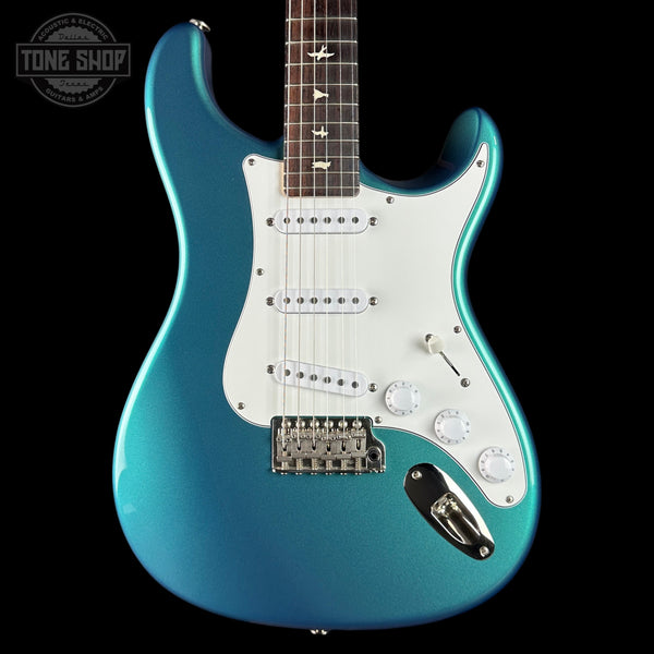 Blue electric guitar with a white pickguard on a black background, featuring the Tone Shop logo.