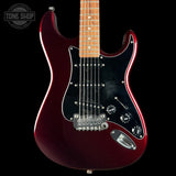 A classic electric guitar with a glossy dark red body, black pickguard, maple neck, and chrome hardware, shown against a solid black background with a Tone Shop watermark in the top left corner.