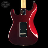 Close-up of the back of an electric guitar with a glossy dark red body, maple neck, black pickguard, and visible 'Gibson' logo on the backplate against a black background.