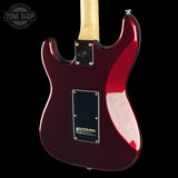 Rust-eze electric guitar body in a metallic deep burgundy red finish, featuring a black pickguard and maple neck, shown against a solid black background.