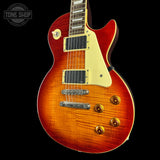 Electric guitar with a sunburst finish on a black background, featuring the Tone Shop logo.