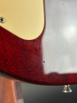 Close-up of a guitar headstock with a red and white design.