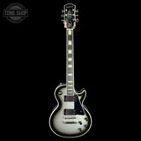 A Gibson electric guitar with a silver-to-black gradient finish, shown from the front against a solid black background. A Tone Shop watermark is visible in the top-left corner.