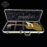 Gold electric guitar in a black case with 'Tone Shop' logo.