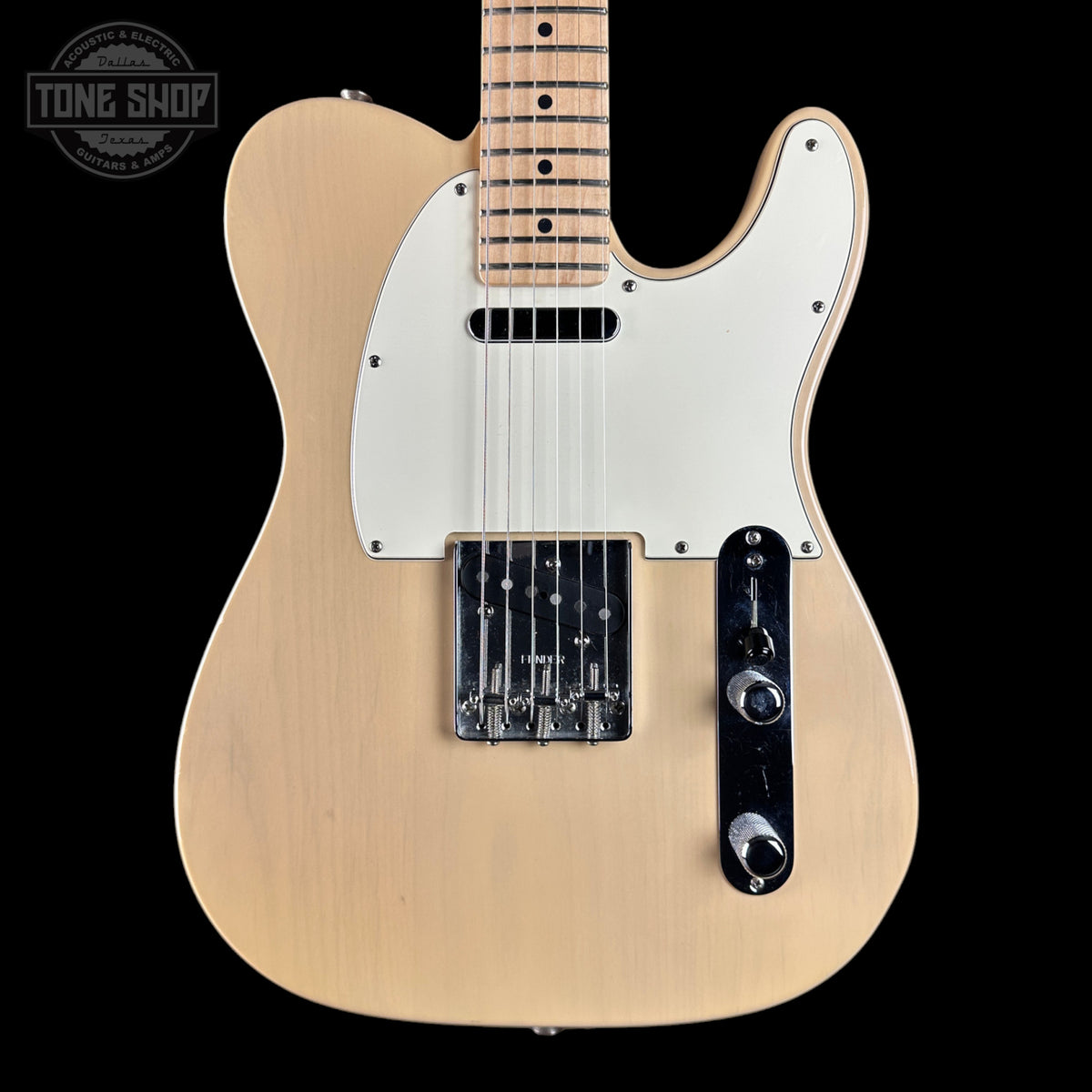 A natural wood electric guitar with a white pickguard and black control plate, shown against a solid black background with a Tone Shop watermark in the top left corner.