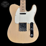 A natural wood electric guitar with a white pickguard and black control plate, shown against a solid black background with a Tone Shop watermark in the top left corner.