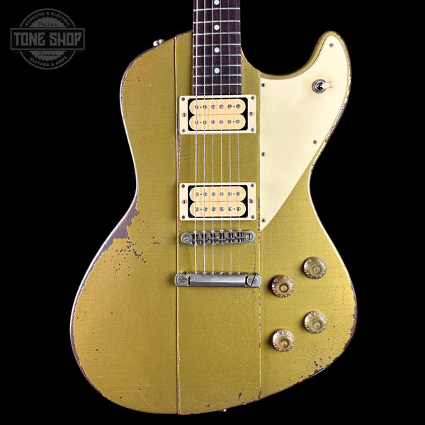 Vintage-style electric guitar with a worn finish on a black background, featuring the Tone Shop logo.