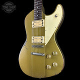 Vintage gold electric guitar with a black background, featuring the Tone Shop logo.