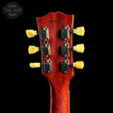 Close-up of a guitar headstock with tuning pegs on a black background, featuring the Tone Shop logo.
