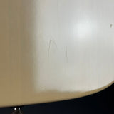 Close-up of a cream-colored lamp shade with visible scratches and scuffs on the surface, set against a dark background.