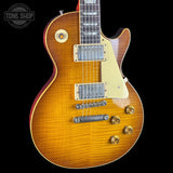Gibson Les Paul guitar with a sunburst finish on a black background, featuring the Tone Shop logo.