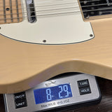 Close-up of a guitar body resting on a digital scale to show weight, with the scale displaying 8.29 oz.
