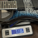 A close-up of a guitar body resting on a digital scale, showing the scale reading 7.136 oz.